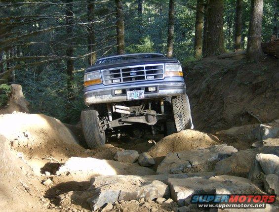 Blue 1995 Ford Bronco navigating rocky terrain