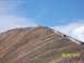 1994 Ford Bronco - Multiple off-road vehicles ascend a mountain trail on a clear day.