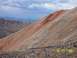 1994 Ford Bronco - A scenic view of a rocky mountain slope with a dirt road winding through it under a dramatic sky.