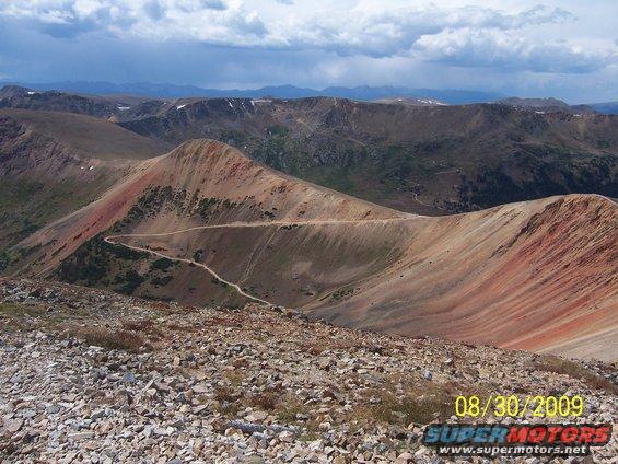 Mountainous terrain with a winding dirt road. Date stamp reads 08/30/2009