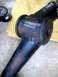 1996 Ford Bronco - Close-up of a worn and cracked black suspension bushing on a metal component, likely needing replacement.
