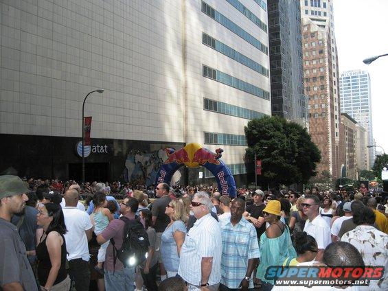 Crowd gathered under Red Bull archway in city