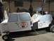 1986 Ford Bronco - A custom-built soapbox derby car designed to look like a Ford Bronco and a police car is displayed outdoors.