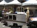 1986 Ford Bronco - A custom-built vehicle, possibly a soapbox derby entry, is displayed under tents with people around.