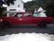 1994 Ford F-350 - A red 1994 Ford F-350 crew cab pickup truck is parked in a gravel driveway next to a house.