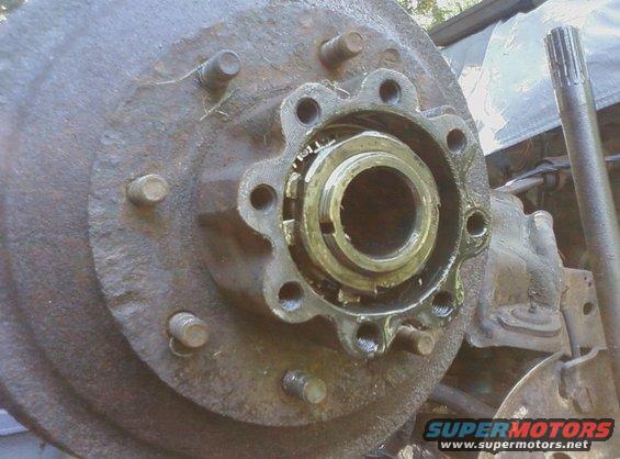 Rusty wheel hub assembly with visible bearing and lug studs