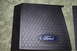 2004 Ford Mustang - This part features the iconic Ford oval emblem set against a hexagonal textured surface.