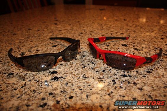 Black and red sunglasses on a speckled countertop. "SUPERMOTORS" logo visible