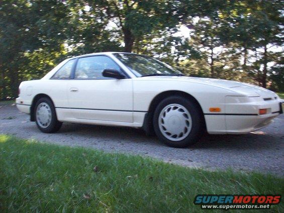 White 1992 Nissan 240SX parked on a gravel road with trees in the background