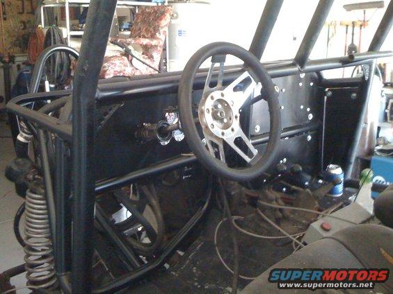 Custom off-road vehicle interior with roll cage and aftermarket steering wheel