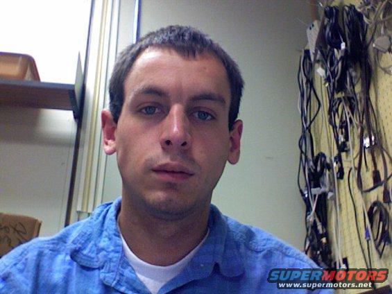 Man in blue shirt with wires in background