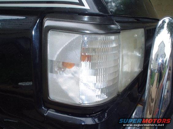 Black SUV front corner with chrome bumper and clear turn signal
