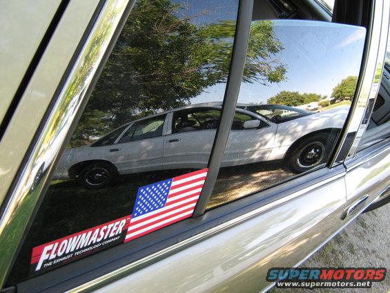 White 2000 Mercury Grand Marquis sedan reflected in a car window, side view