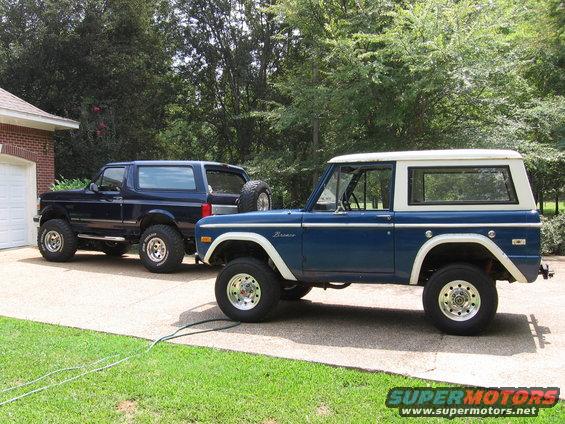 blue 1970s Ford Bronco next to a dark blue 1990s Ford Bronco