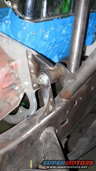 Custom suspension bracket attached to vehicle frame near engine block