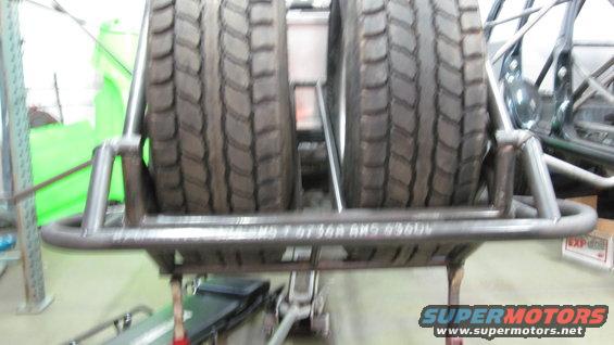 Spare tire carrier with two tires mounted, showing metal tubing construction and tread detail
