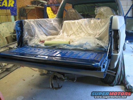 Blue pickup truck bed, tailgate down, interior covered. Supermotors.net logo visible