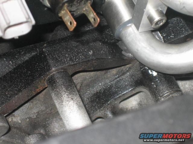 sw-mod-10.jpg the block has to be notched 3/8 of a inch inorder for the outlet tube to fit.  It is designed this way.  I strongly recommend a 90 degree die grinder and a heavy duty burr.  Just make sure you tape the ports shut while modifying  It also helps to just put the lower manifold and tube in the valley  and trim till the required clearance is achieved   Just keep in mind that the intake gaskets will compress some.