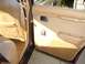 1984 Ford LTD - Interior view of a car's door panel and seat, showing tan and beige upholstery.