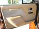 1984 Ford LTD - Interior door panel of a car, showing tan upholstery and chrome accents, with a visible Supermotors.net watermark.