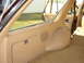 1984 Ford LTD - The rear interior of a station wagon features tan carpeting and trim panels with a visible storage compartment and speaker grille.