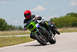 2001 Kawasaki KZ1000-A1 - Riders compete on a track, with the lead motorcycle a distinctive green fairing and a rider in a red helmet.