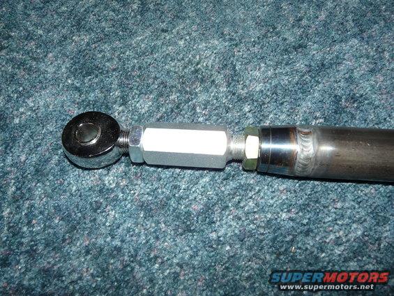 Close-up of an adjustable suspension part with a threaded rod and a heim joint