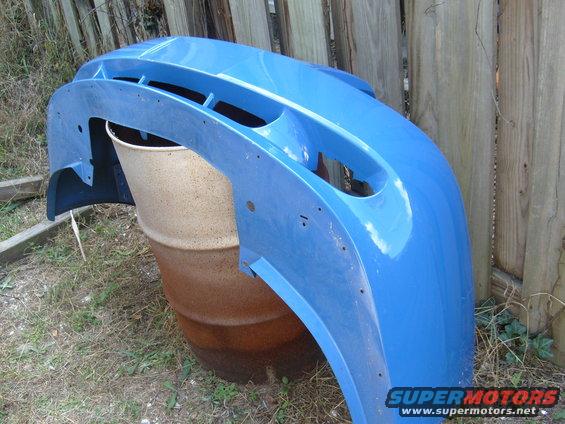 blue plastic bumper leaning against a barrel