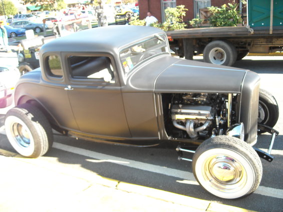 Matte gray hot rod coupe with exposed engine and whitewall tires