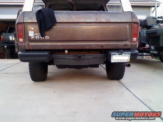 Brown Ford Bronco rear with a black spare tire cover and a Colorado license plate. Another vehicle is visible to the left