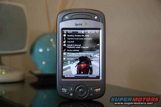 Sprint phone displaying date, time, and a motorcycle image on its screen
