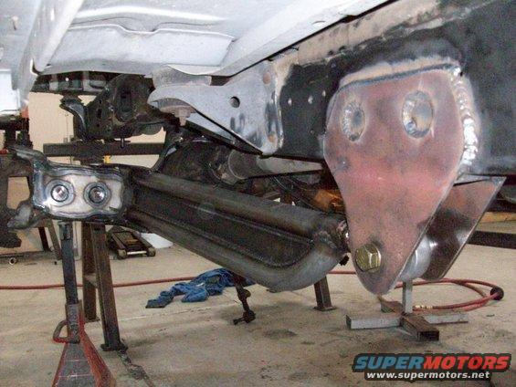 Close-up of vehicle frame and suspension parts, possibly undergoing modification