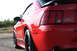 2004 Ford Mustang - Rear view of a red 2004 Ford Mustang Mach 1 showing the quarter panel and 'mach 1' badging.