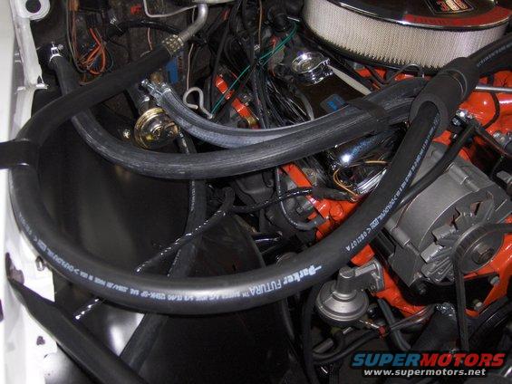 Engine bay with hoses and alternator visible