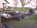 1900 Ford C-350 (Centurion Conversions) - A trailer is parked in a yard, loaded with various parts and an ATV on the back.