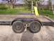 1900 Ford C-350 (Centurion Conversions) - A dual axle trailer sits in a gravel driveway with a swing set and slide visible in the background.