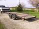 1900 Ford C-350 (Centurion Conversions) - A white Dodge pickup truck is hitched to a wooden car hauler trailer on a gravel driveway.