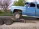 1900 Ford C-350 (Centurion Conversions) - A blue pickup truck, identified by its 'Silverado' badging, is loaded onto a trailer.