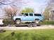 1900 Ford C-350 (Centurion Conversions) - A light blue extended cab pickup truck is being transported on a dual-axle trailer.