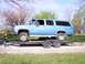 1900 Ford C-350 (Centurion Conversions) - Blue Chevrolet Suburban loaded onto a trailer, with a young child observing.