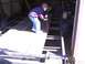 1900 Ford C-350 (Centurion Conversions) - A boy works on a trailer frame inside a garage.