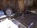 1900 Ford C-350 (Centurion Conversions) - Metal frame for a trailer is being assembled in a workshop with tools and spare tires visible.