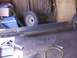 1900 Ford C-350 (Centurion Conversions) - Workshop scene with steel beams and a spare tire, possibly for a trailer or heavy equipment.
