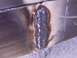 1900 Ford C-350 (Centurion Conversions) - A close-up view of a weld seam on a metal panel, showing signs of repair or construction.