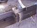 1900 Ford C-350 (Centurion Conversions) - A close-up view of a metal frame being welded, with a grinder and chalk markings visible.