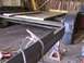 1900 Ford C-350 (Centurion Conversions) - Trailer frame construction in progress with wooden planks and welding gear.