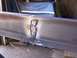 1900 Ford C-350 (Centurion Conversions) - A close-up view of a steel beam showing a rough weld with slag and debris scattered around it.