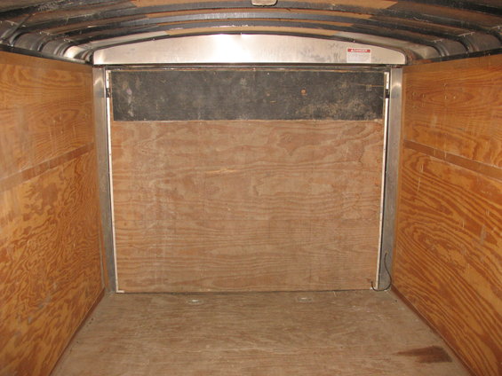 Interior of a cargo trailer with wood paneling and metal trim