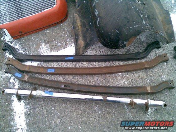Several car suspension parts and a section of a grille on concrete