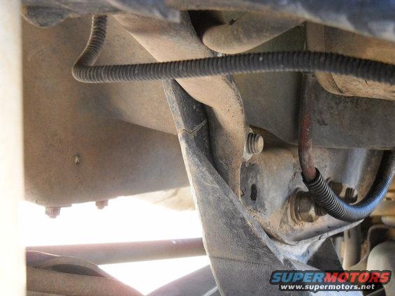 Close-up of truck frame and suspension components. Shows wiring and bolts